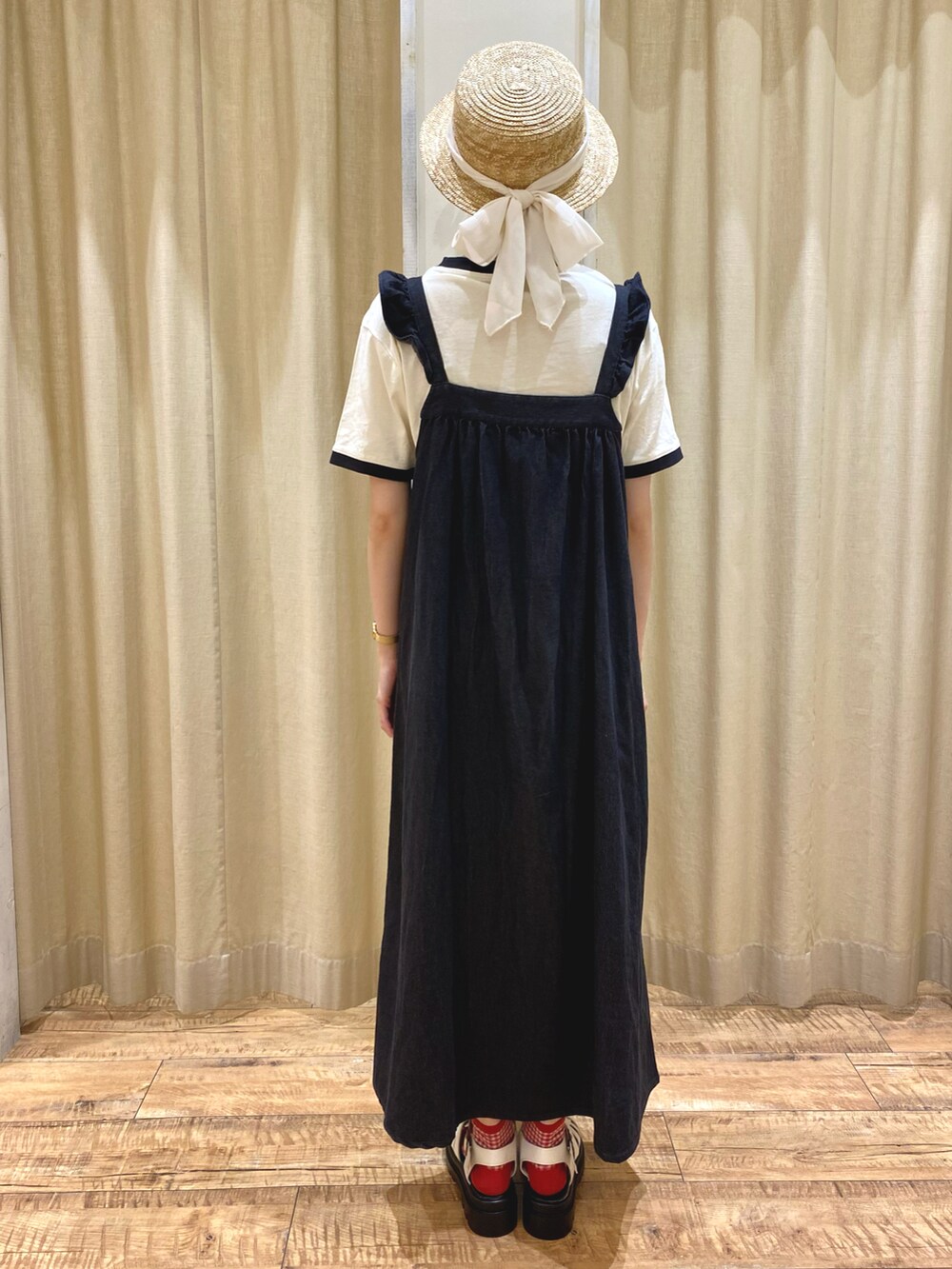 ブラック系のワンピース、ホワイト系のTシャツ/カットソー、ホワイト系のサンダルを着用したレディースの春コーディネートの3枚目の写真