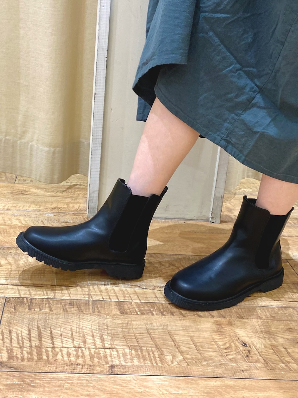 グリーン系のワンピース/ドレス、ブラック系のブーツ、ブラック系のハットを着用したレディースの秋コーディネートの5枚目の写真