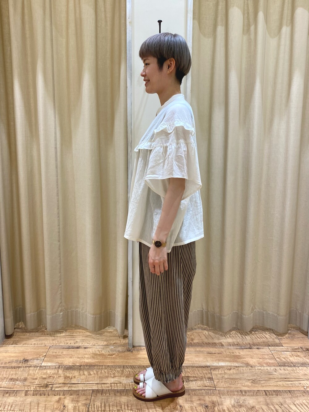 ホワイト系のシャツ/ブラウス、ベージュ系のその他パンツ、ブラウン系のハンドバッグを着用したレディースの夏コーディネートの2枚目の写真