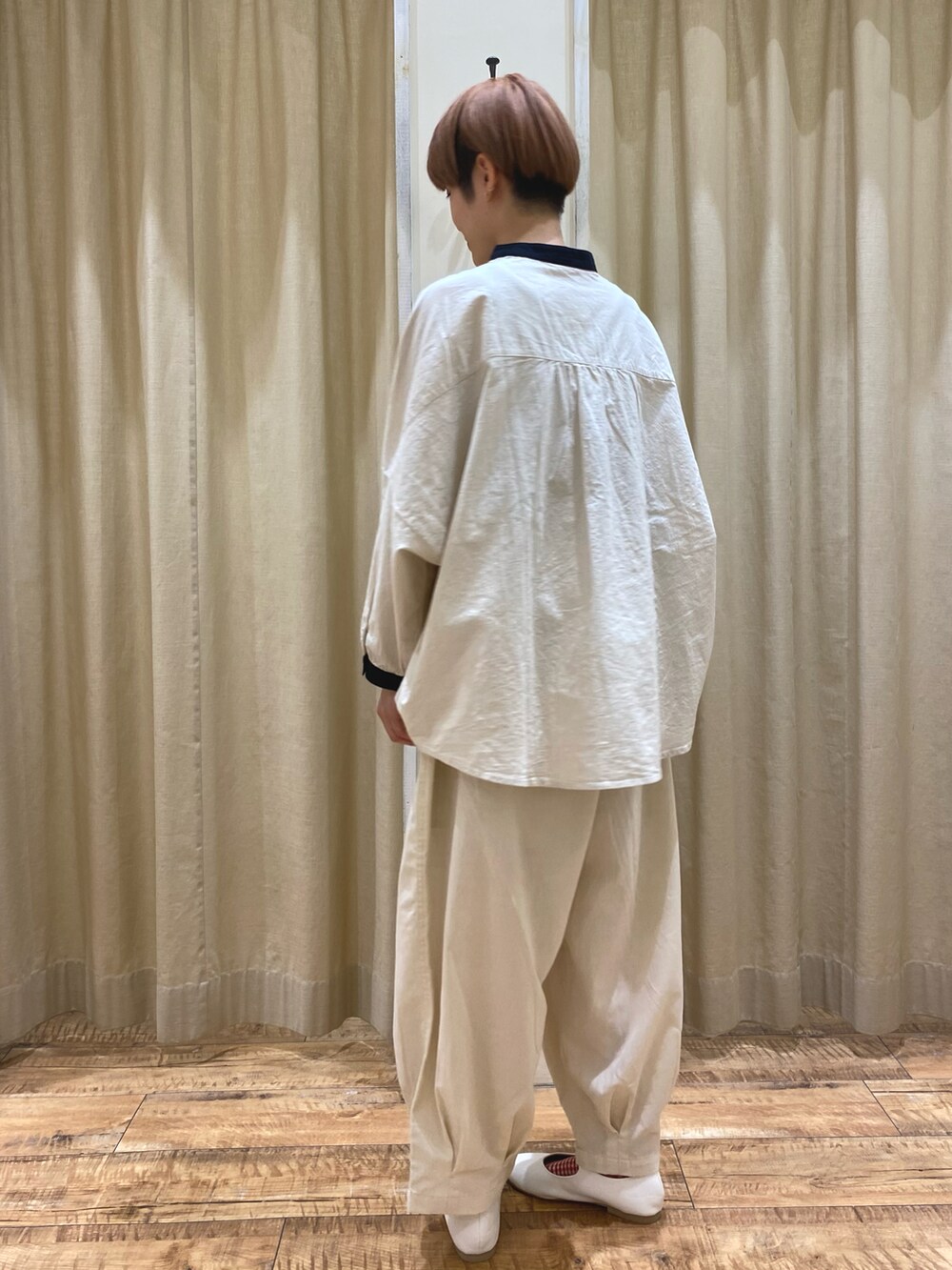 ベージュ系のシャツ/ブラウス、ホワイト系のその他パンツ、ブラック系のハンドバッグを着用したレディースの春コーディネートの4枚目の写真