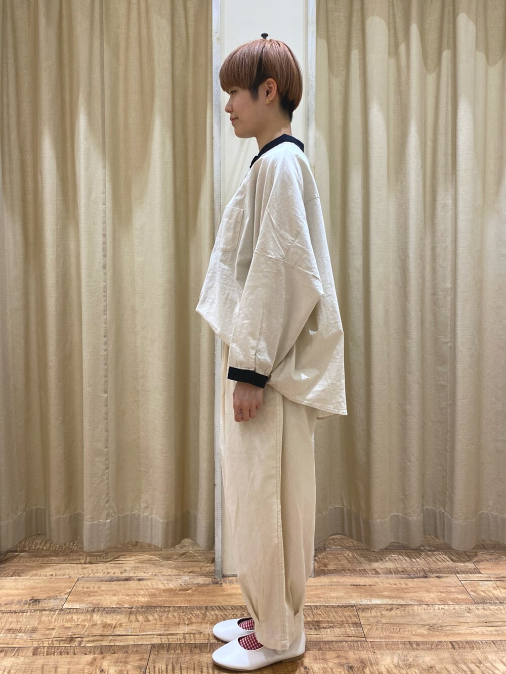 ベージュ系のシャツ/ブラウス、ホワイト系のその他パンツ、ブラック系のハンドバッグを着用したレディースの春コーディネートの2枚目の写真