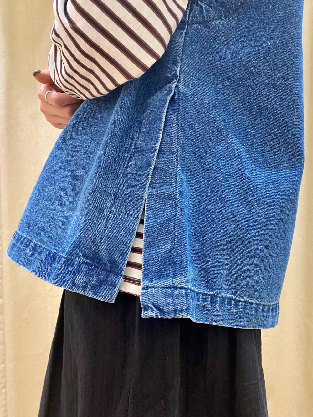 ブルー系のベスト、ブラック系のスカート、ホワイト系のTシャツ/カットソーを着用したレディースの冬コーディネートの4枚目の写真