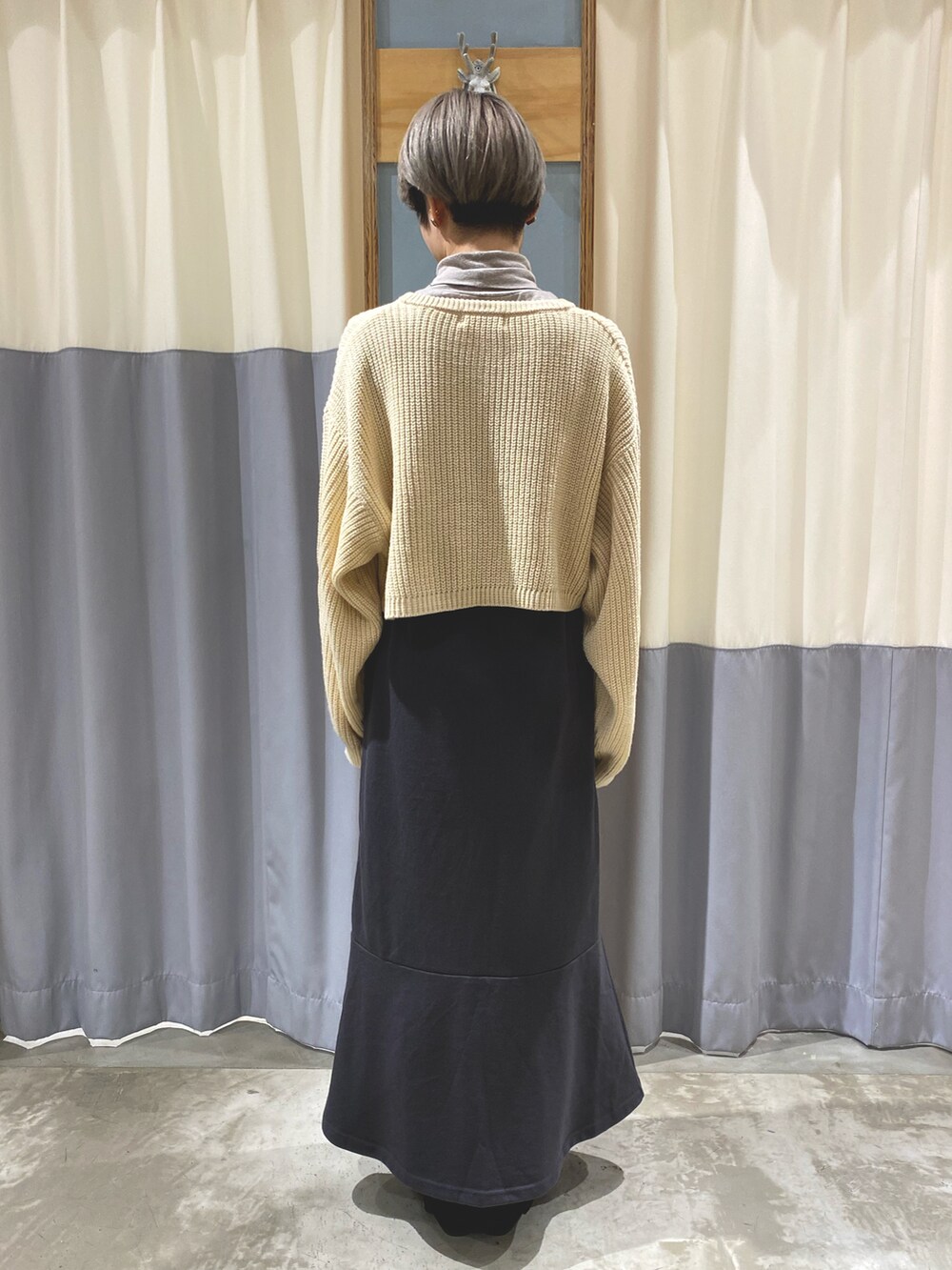 ホワイト系のカーディガン/ボレロ、グレー系のスカート、ブラウン系のショルダーバッグを着用したレディースの秋コーディネートの3枚目の写真