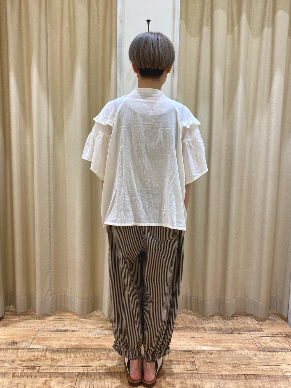 ホワイト系のシャツ/ブラウス、ベージュ系のその他パンツ、ブラウン系のハンドバッグを着用したレディースの夏コーディネートの3枚目の写真