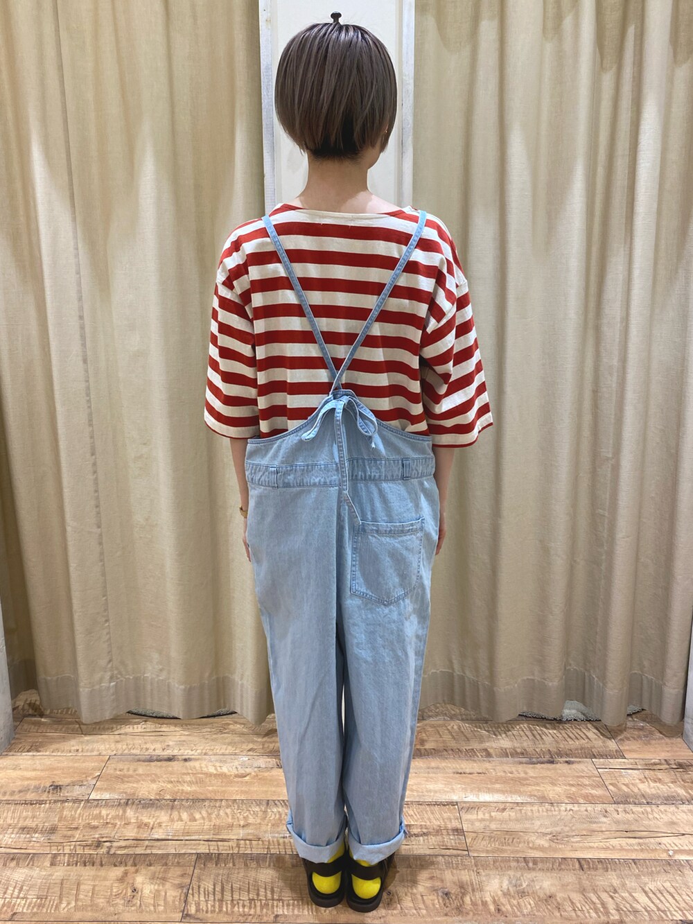 レッド系のTシャツ/カットソー、ブルー系のサロペット/オーバーオール、ブラウン系のサンダルを着用したレディースの春コーディネートの3枚目の写真