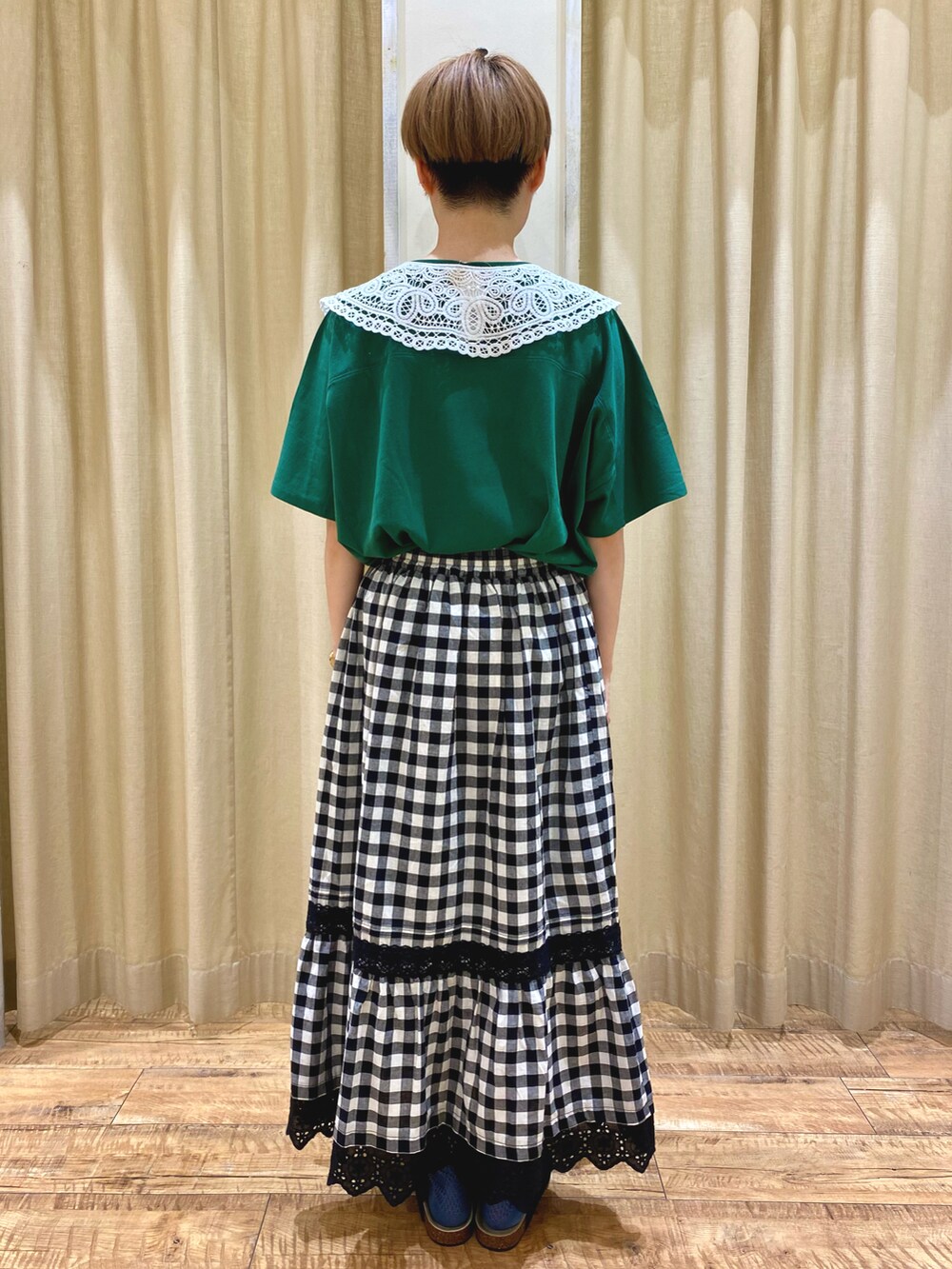 ブラック系のスカート、グリーン系のTシャツ/カットソー、ホワイト系のハンドバッグを着用したレディースの春コーディネートの3枚目の写真