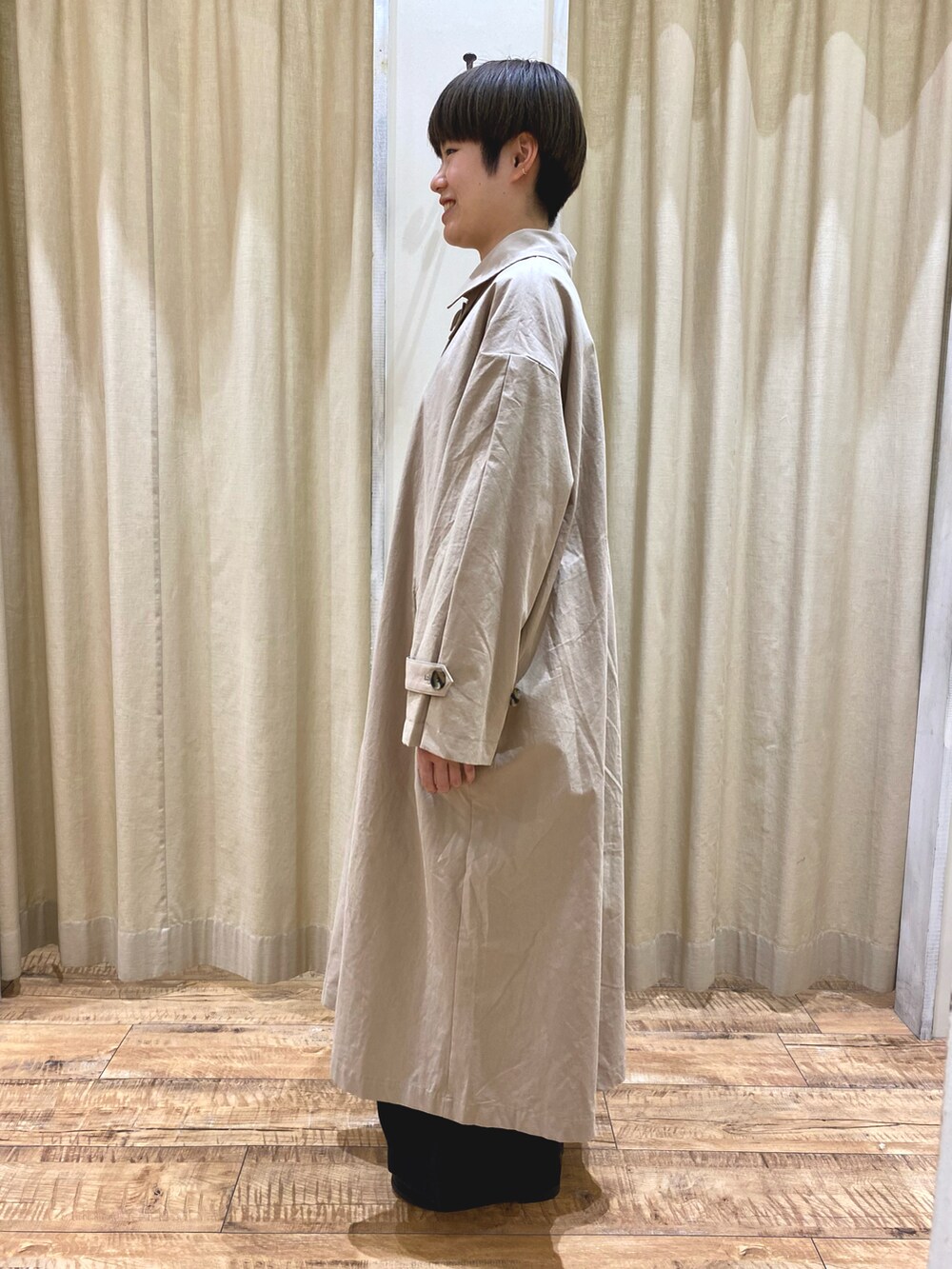 ベージュ系のステンカラーコート、ブラック系のその他シューズ、ブラック系のショルダーバッグを着用したレディースの秋コーディネートの3枚目の写真