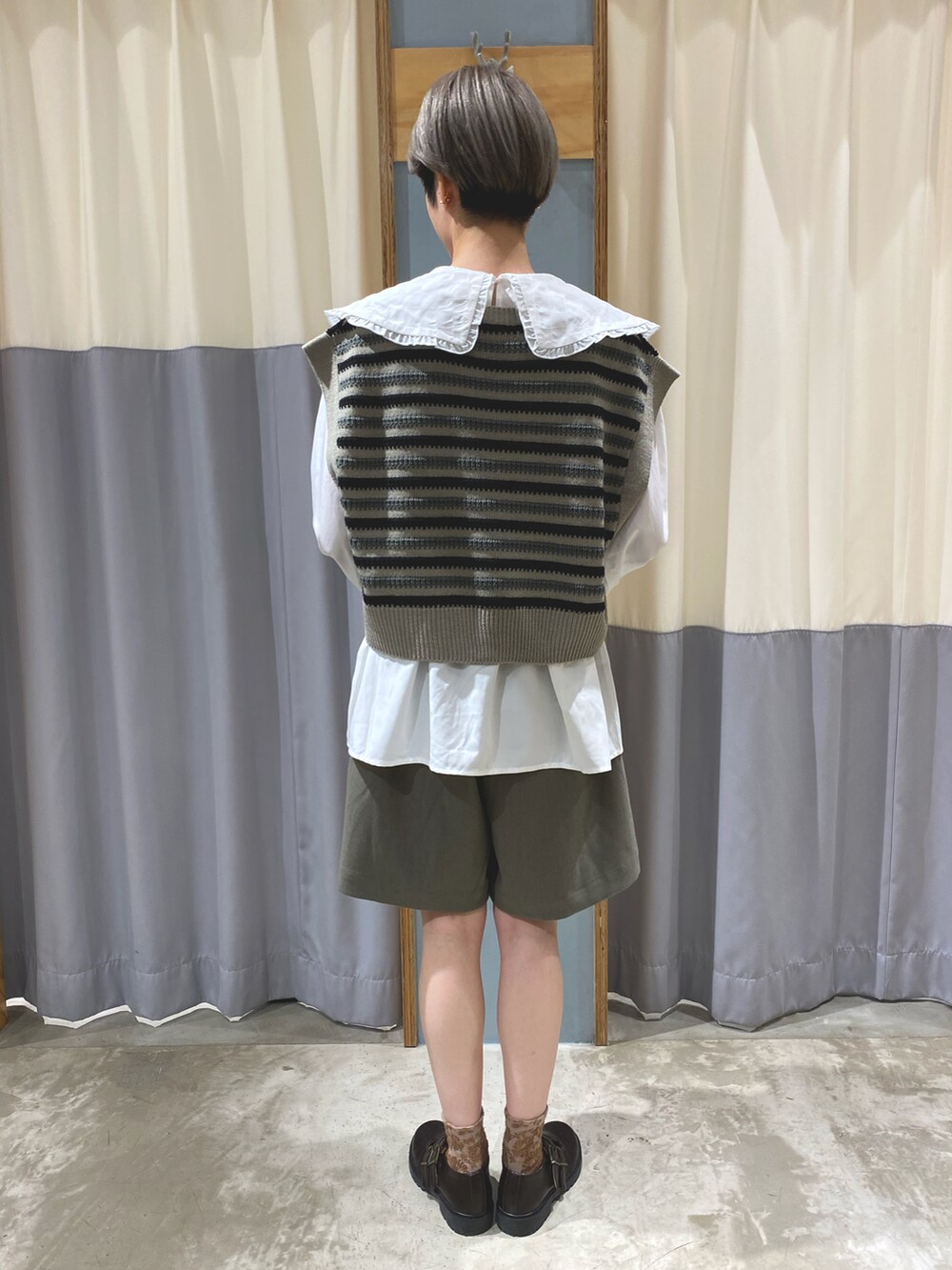 ブラック系のベスト、グリーン系のその他パンツ、ホワイト系のシャツ/ブラウスを着用したレディースの秋コーディネートの4枚目の写真