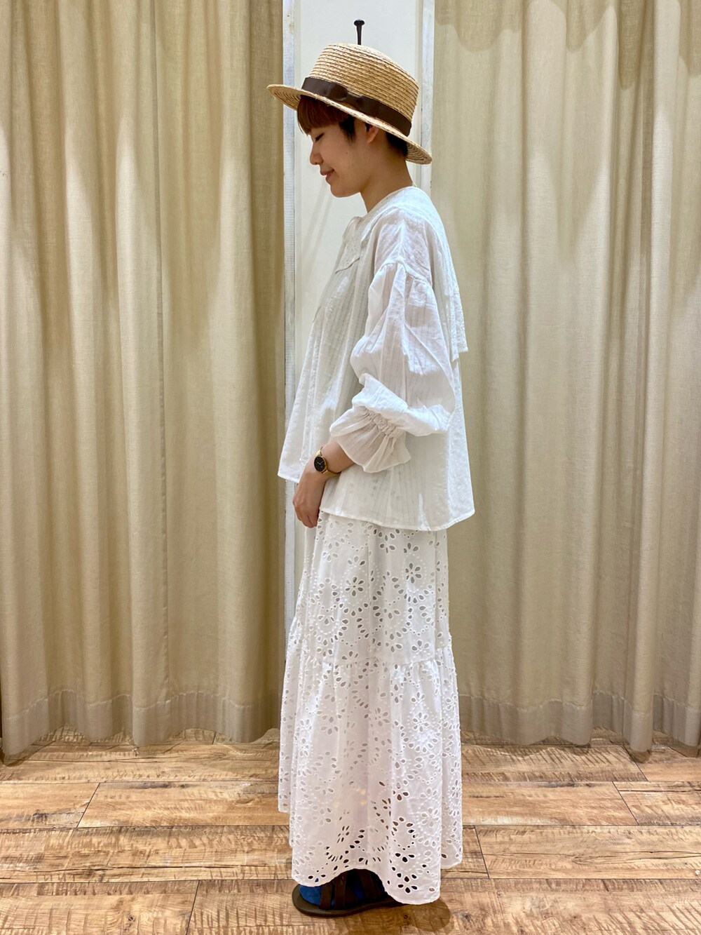 ホワイト系のシャツ/ブラウス、ホワイト系のスカート、グリーン系のタンクトップを着用したレディースの春コーディネートの2枚目の写真