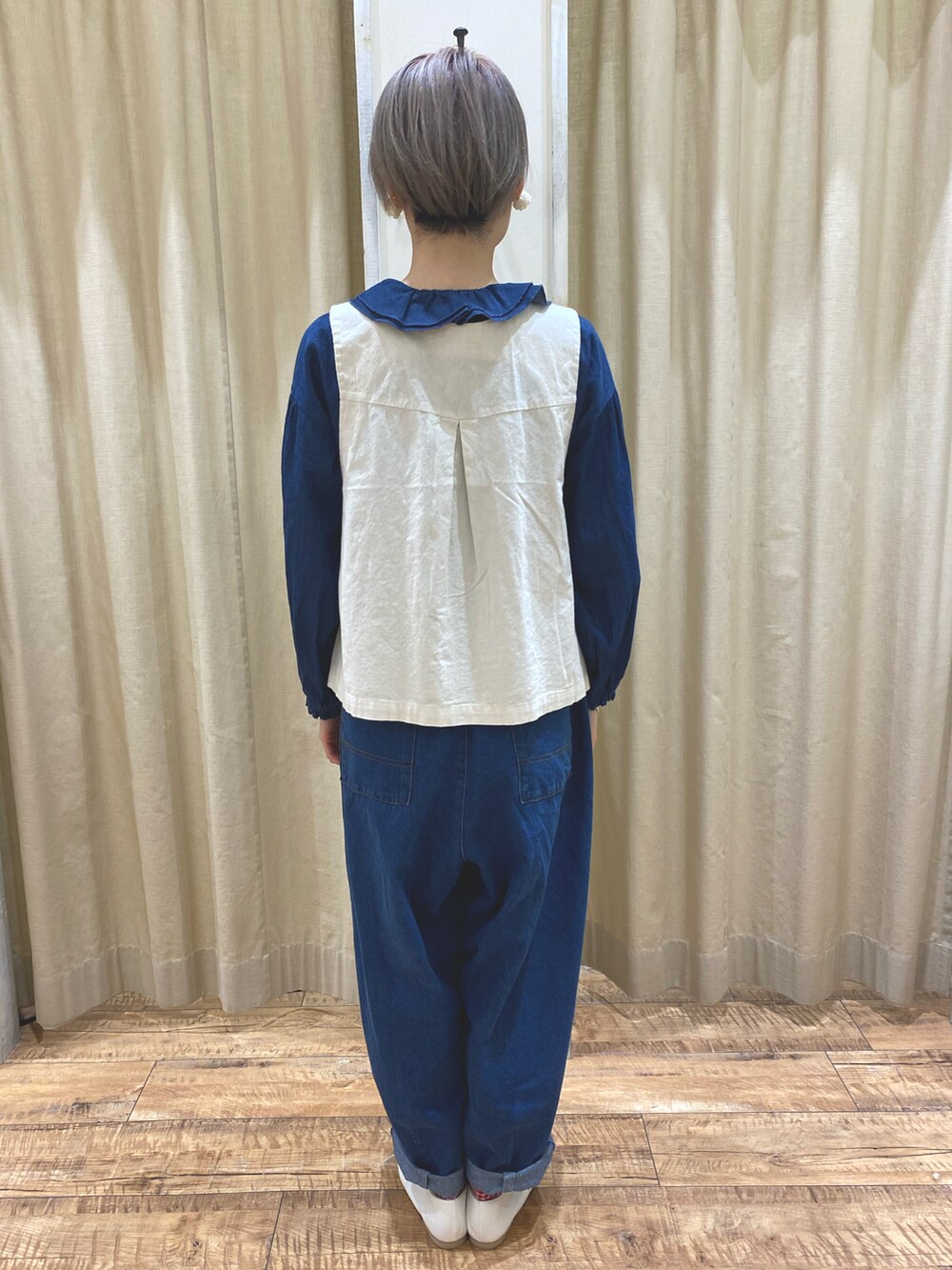 ホワイト系のベスト、ブルー系のシャツ/ブラウス、ブルー系のデニムパンツを着用したレディースの春コーディネートの3枚目の写真