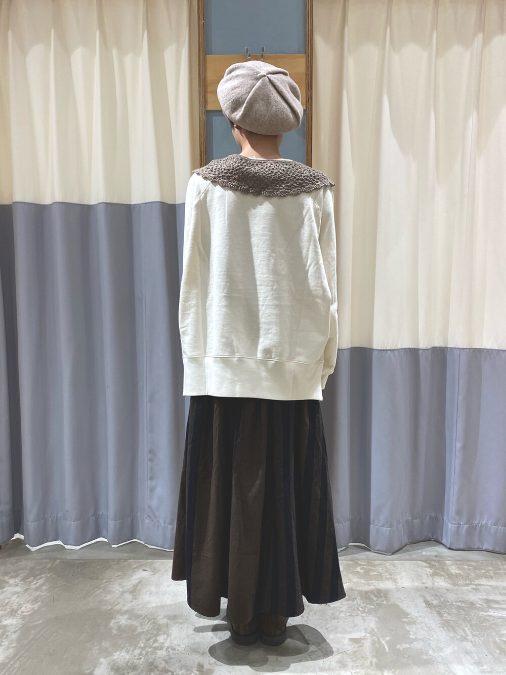 ホワイト系のスウェット、ブラウン系のスカート、ベージュ系のブーツを着用したレディースの秋コーディネートの2枚目の写真