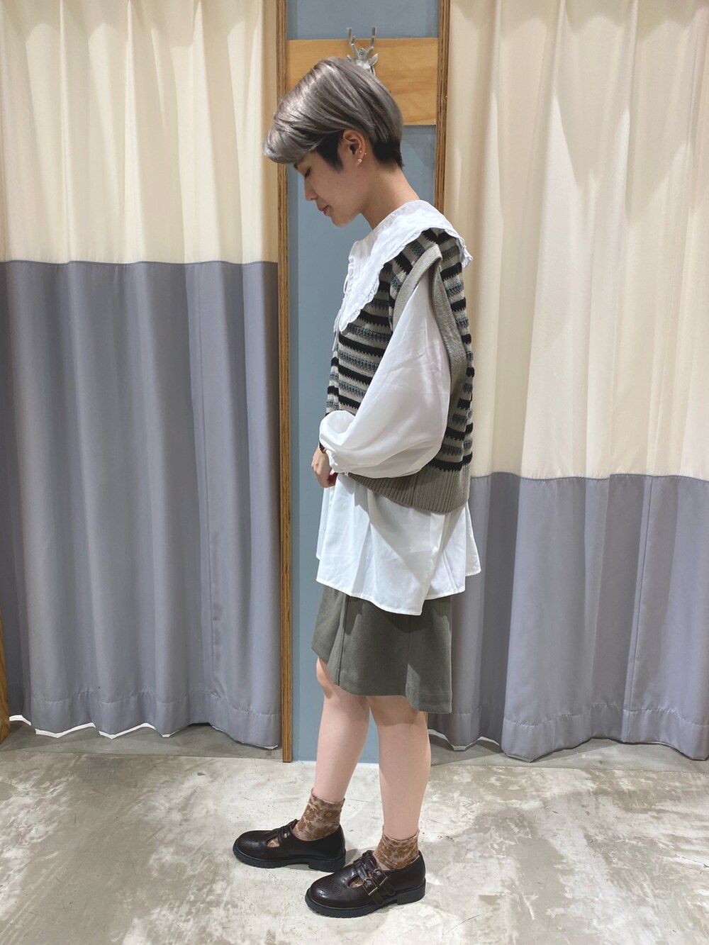 ブラック系のベスト、グリーン系のその他パンツ、ホワイト系のシャツ/ブラウスを着用したレディースの秋コーディネートの3枚目の写真