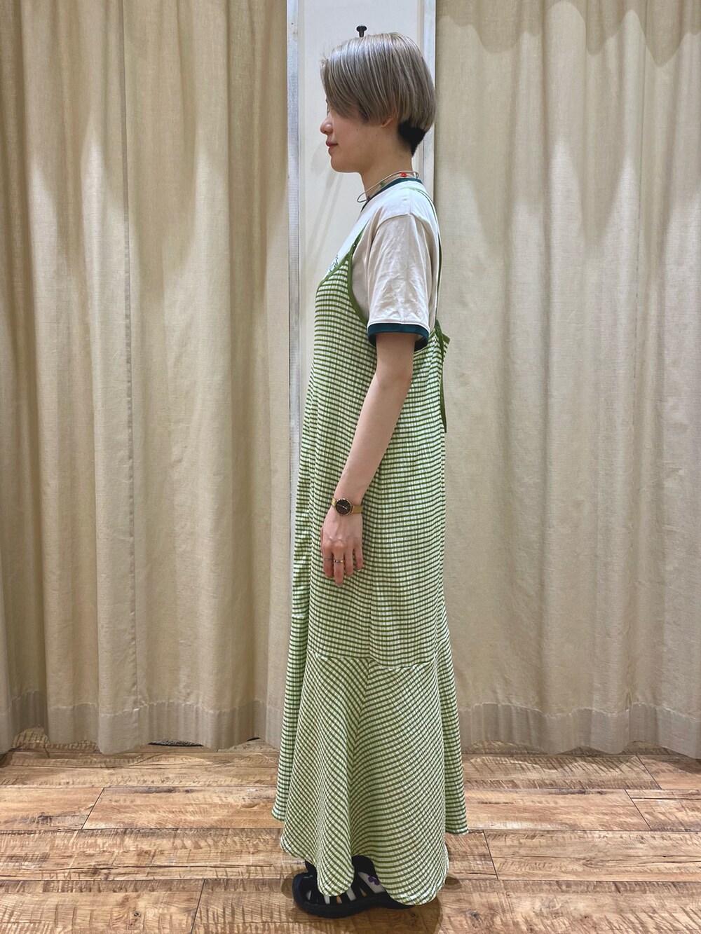 グリーン系のワンピース、ホワイト系のニット/セーターを着用したレディースの春コーディネートの2枚目の写真