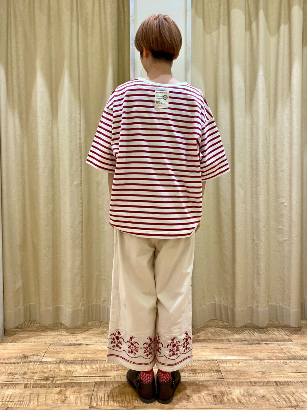 レッド系のTシャツ/カットソー、ホワイト系のその他パンツ、ブラウン系のハンドバッグを着用したレディースの春コーディネートの3枚目の写真