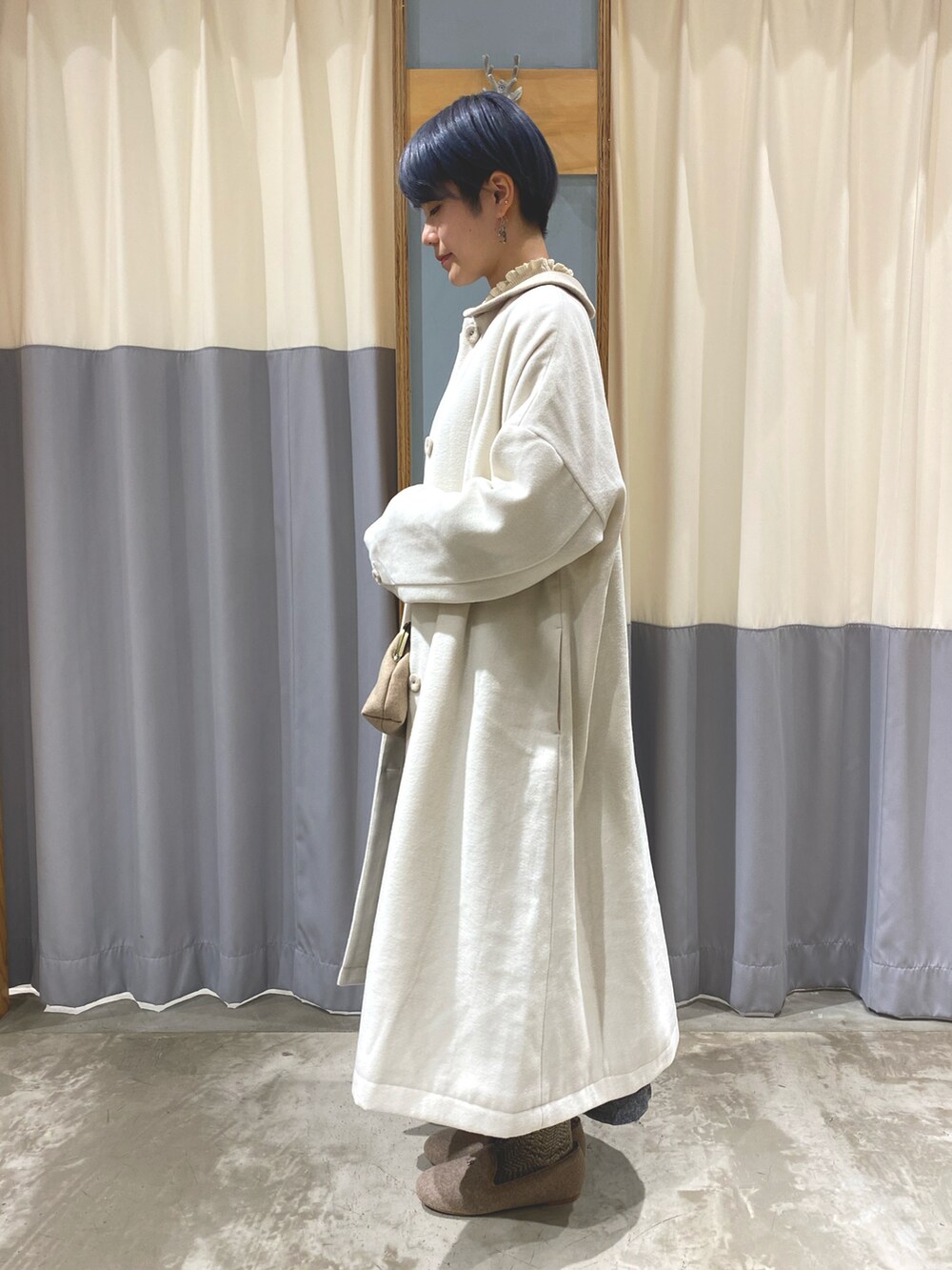 グレー系のジャンパースカート、ベージュ系のショルダーバッグ、ベージュ系のその他シューズを着用したレディースの秋コーディネートの2枚目の写真