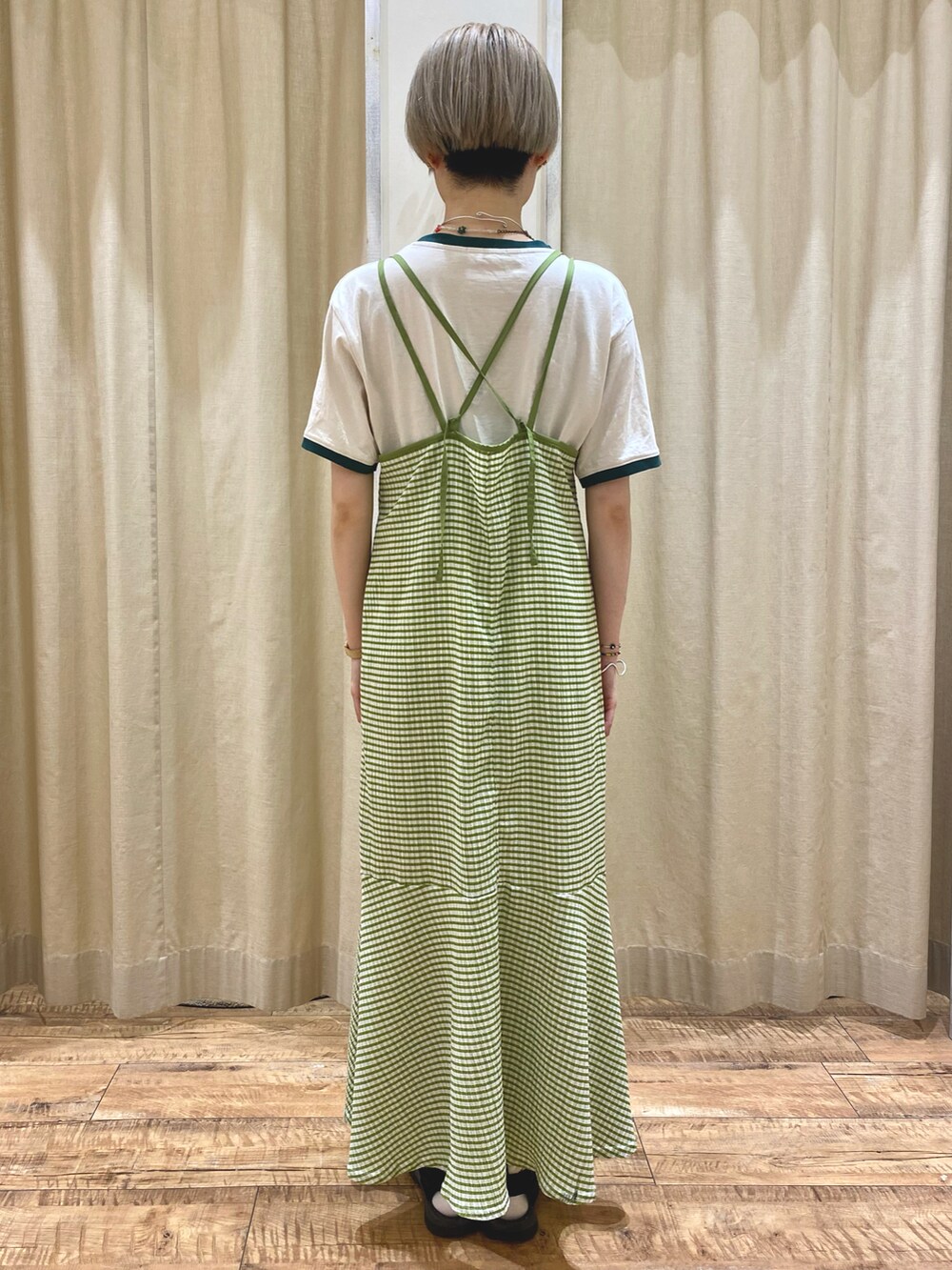 グリーン系のワンピース、ホワイト系のニット/セーターを着用したレディースの春コーディネートの3枚目の写真