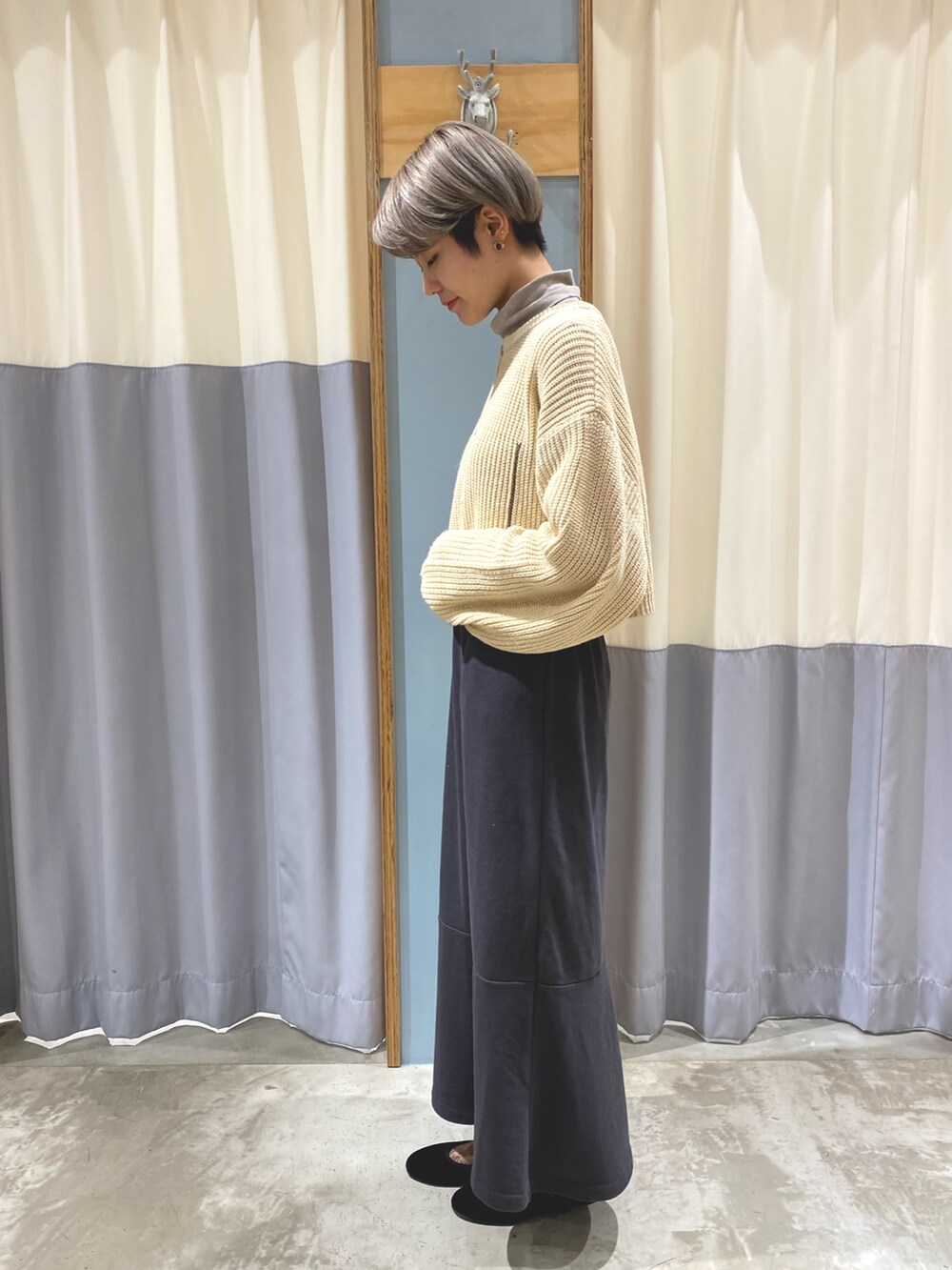 ホワイト系のカーディガン/ボレロ、グレー系のスカート、ブラウン系のショルダーバッグを着用したレディースの秋コーディネートの2枚目の写真