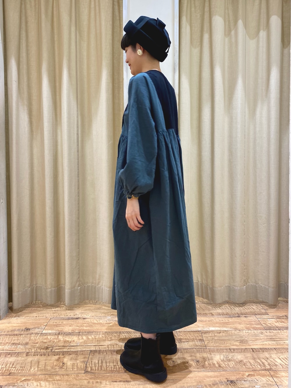 グリーン系のワンピース/ドレス、ブラック系のブーツ、ブラック系のハットを着用したレディースの秋コーディネートの3枚目の写真