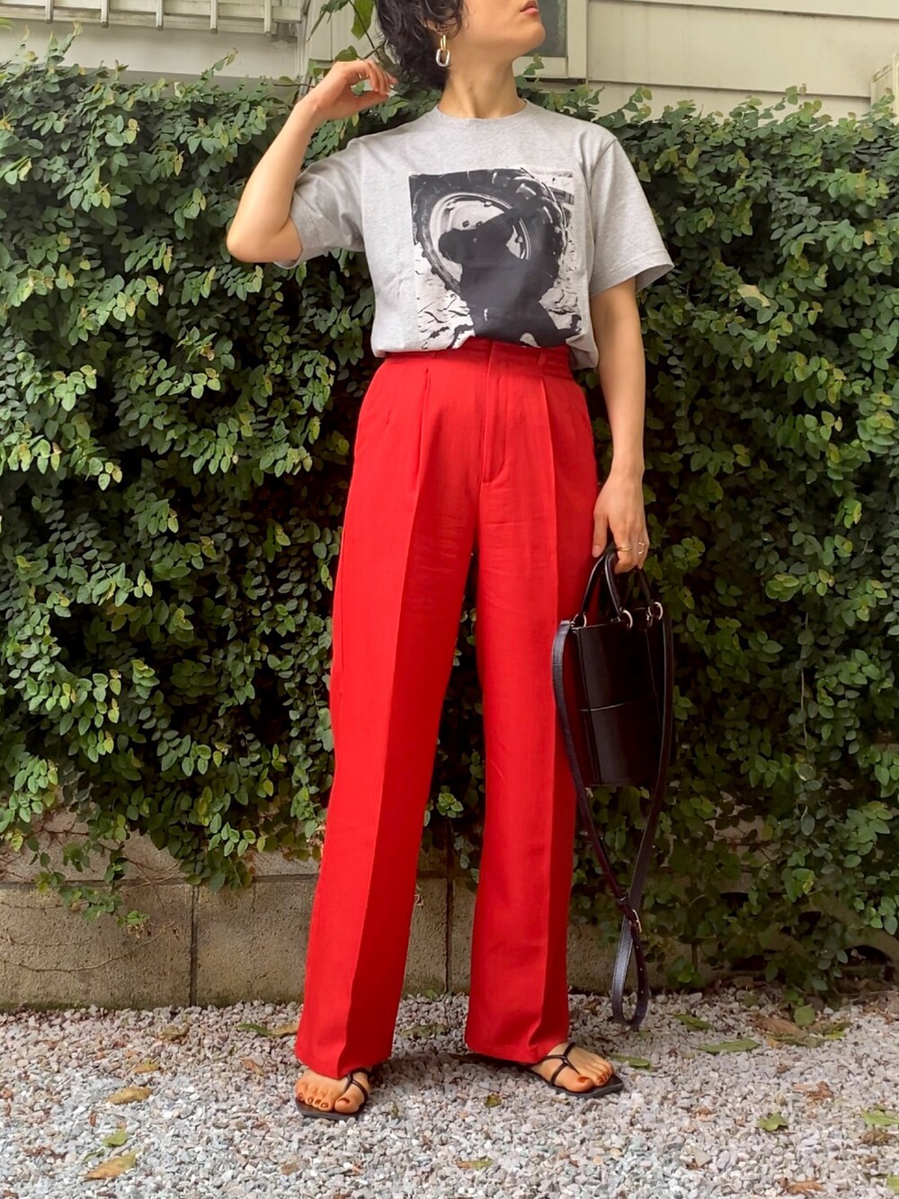 グレー系のTシャツ/カットソー、レッド系のスラックス、ブラック系のハンドバッグを着用したレディースの夏コーディネートの3枚目の写真