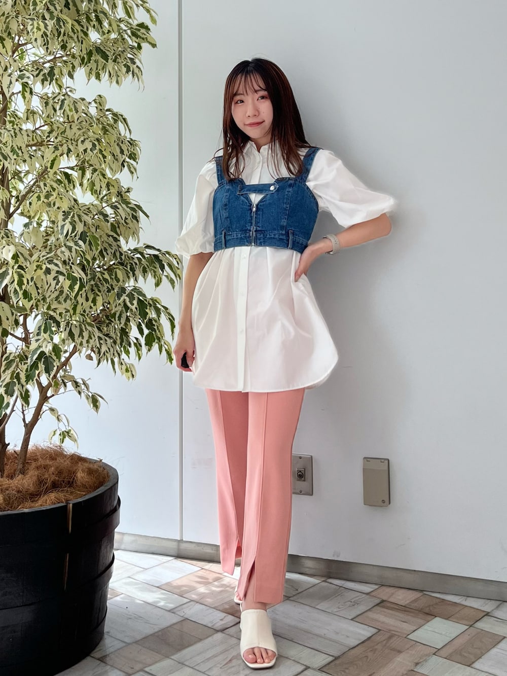 ホワイト系のチュニックを着用したレディースの春コーディネートの2枚目の写真