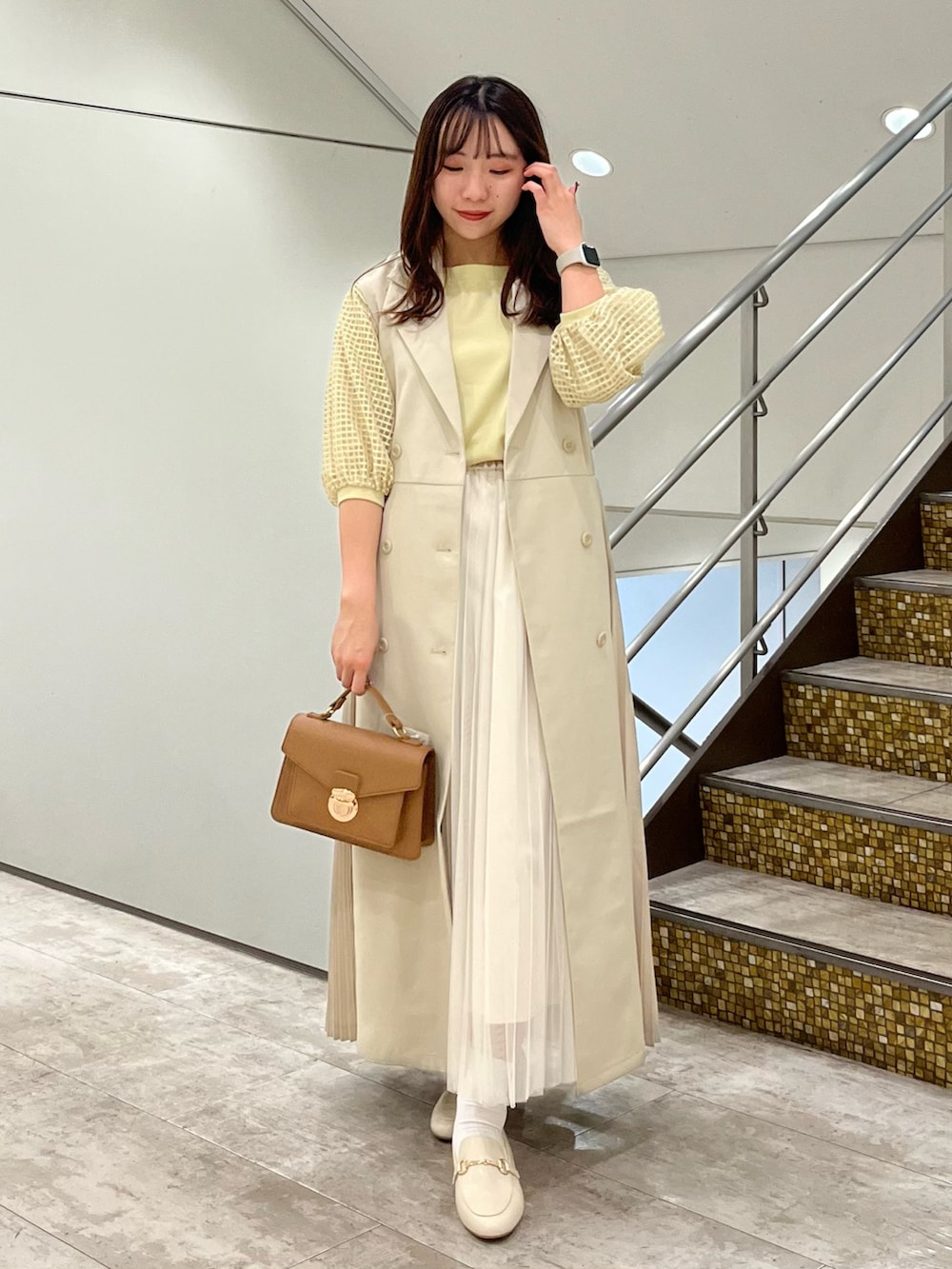 ブラウン系のショルダーバッグ、イエロー系のTシャツ/カットソー、その他のベストを着用したレディースの春コーディネートの2枚目の写真