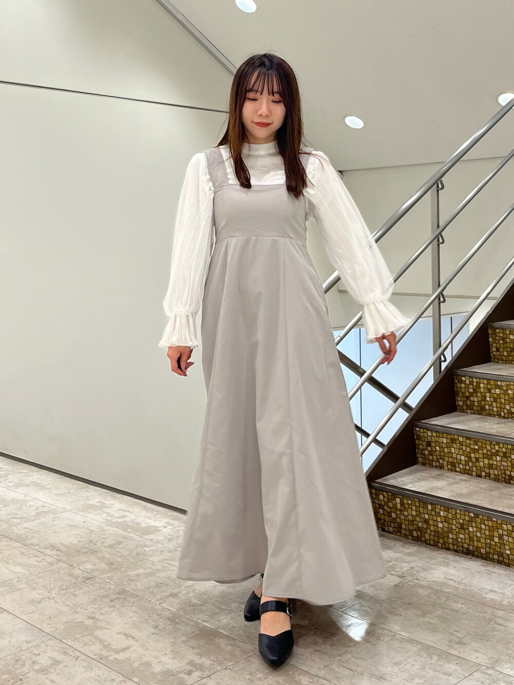 ベージュ系のワンピース、ホワイト系のTシャツ/カットソーを着用したレディースの春コーディネートの2枚目の写真