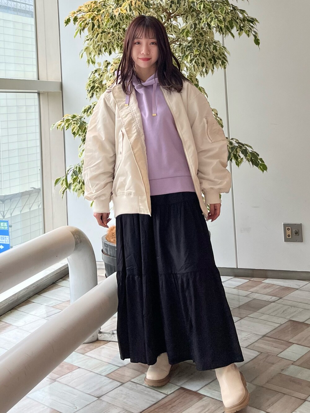 パープル系のスウェット、ブラック系のスカートを着用したレディースの秋コーディネートの2枚目の写真