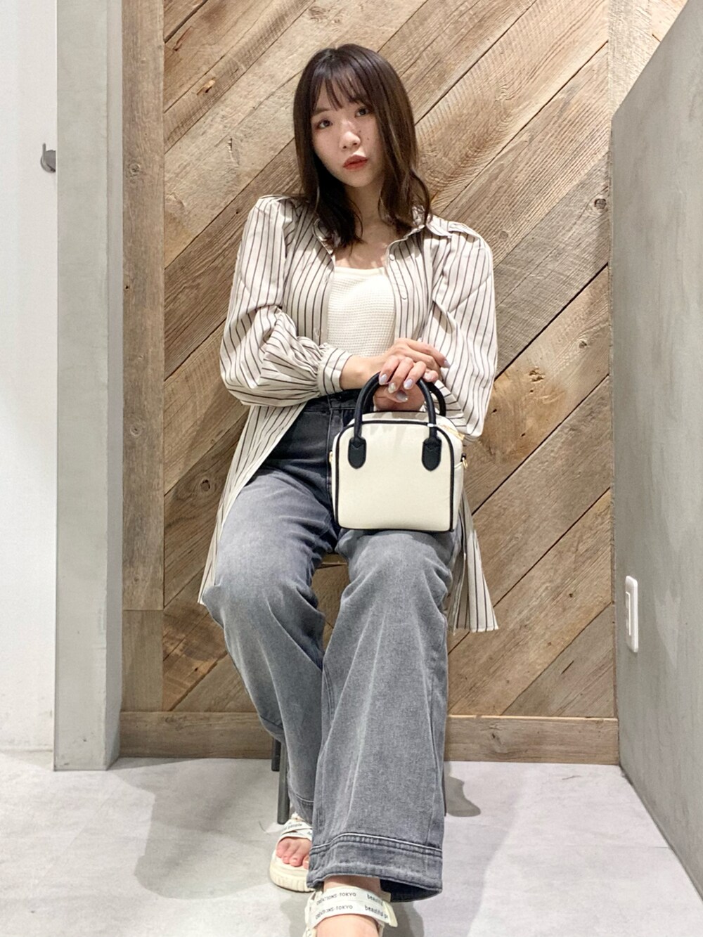 ブラック系のデニムパンツ、ホワイト系のシャツ/ブラウスを着用したレディースの夏コーディネートの2枚目の写真
