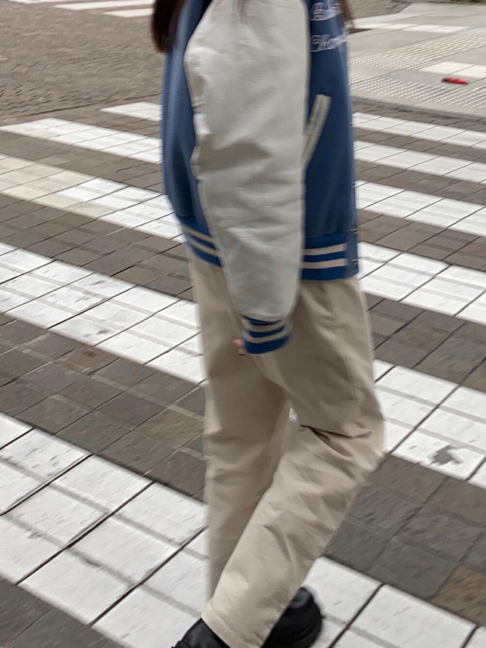 ホワイト系のチノパンツ、ブルー系のスタジャンを着用したレディースの冬コーディネートの2枚目の写真