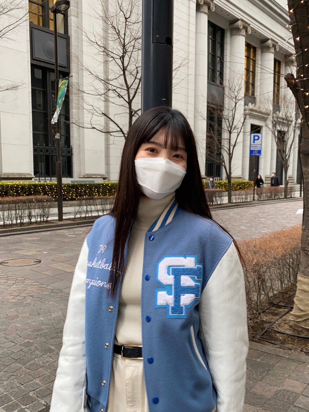 ホワイト系のチノパンツ、ブルー系のスタジャンを着用したレディースの冬コーディネートの3枚目の写真