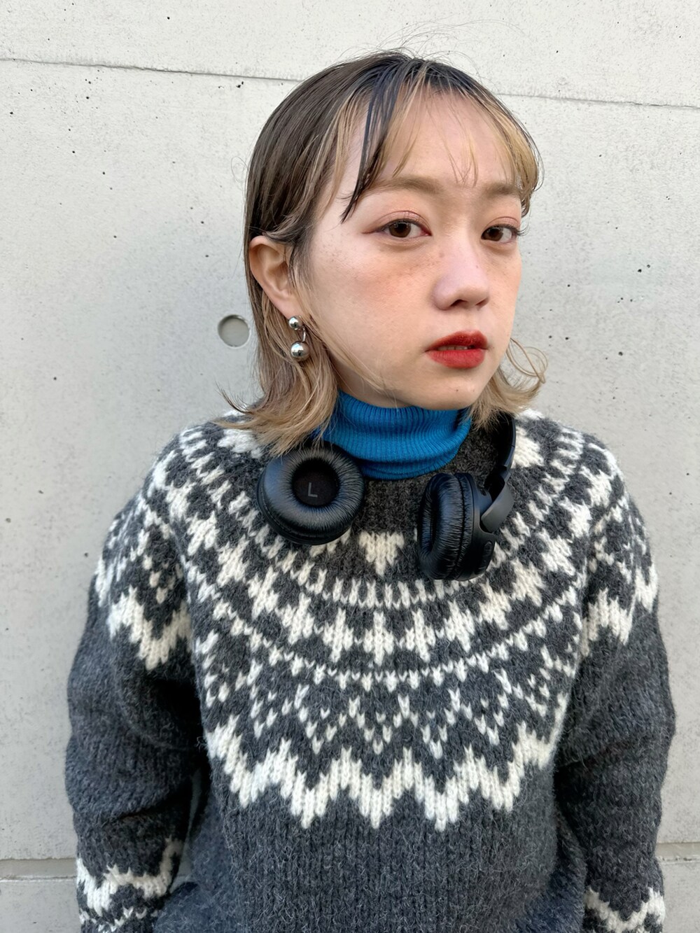 グレー系のニット/セーター、グレー系のパンツ、ブラック系のバッグを着用したレディースの冬コーディネートの2枚目の写真