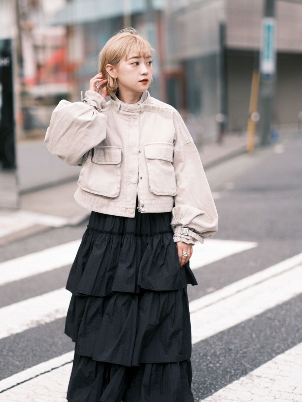 ベージュ系のデニムジャケット、ブラック系のスカート、ブラック系のブーツを着用したレディースの秋コーディネートの5枚目の写真