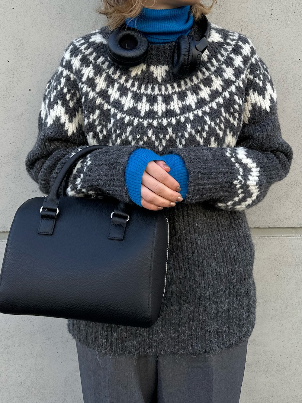 グレー系のニット/セーター、グレー系のパンツ、ブラック系のバッグを着用したレディースの冬コーディネートの4枚目の写真