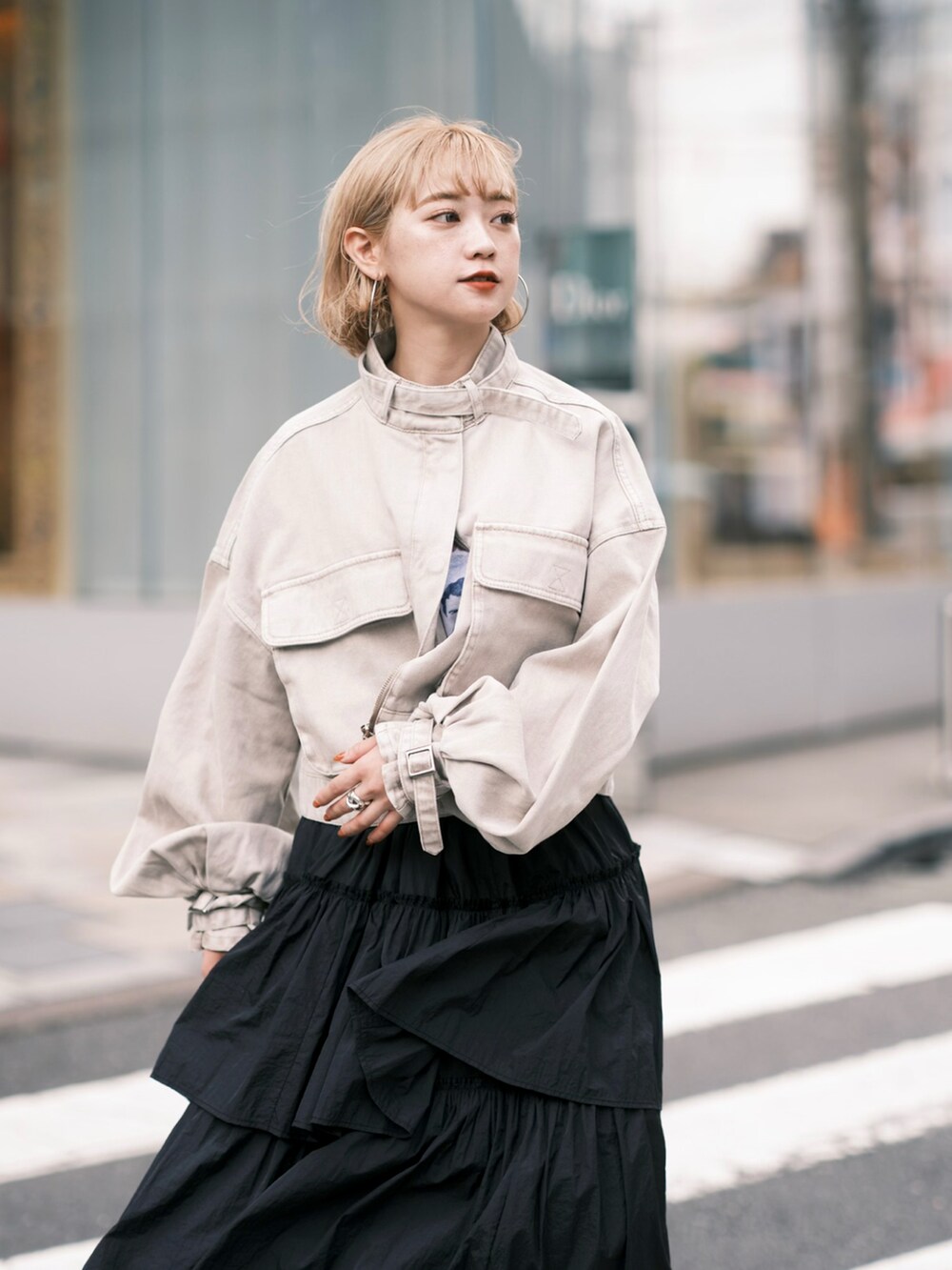 ベージュ系のデニムジャケット、ブラック系のスカート、ブラック系のブーツを着用したレディースの秋コーディネートの2枚目の写真