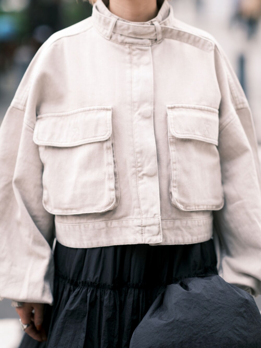 ベージュ系のデニムジャケット、ブラック系のスカート、ブラック系のブーツを着用したレディースの秋コーディネートの4枚目の写真