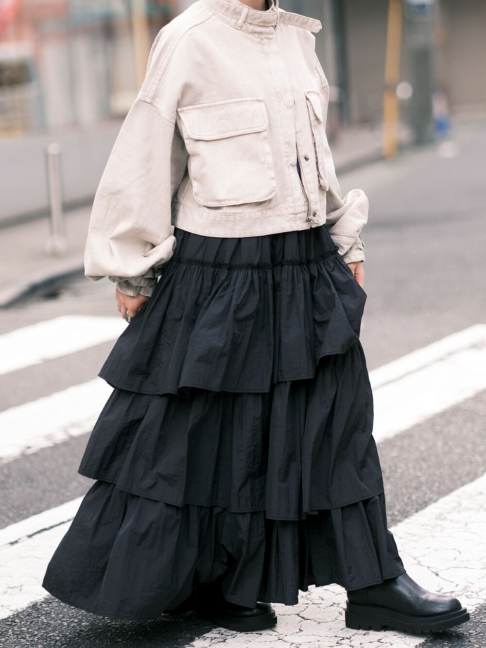 ベージュ系のデニムジャケット、ブラック系のスカート、ブラック系のブーツを着用したレディースの秋コーディネートの3枚目の写真