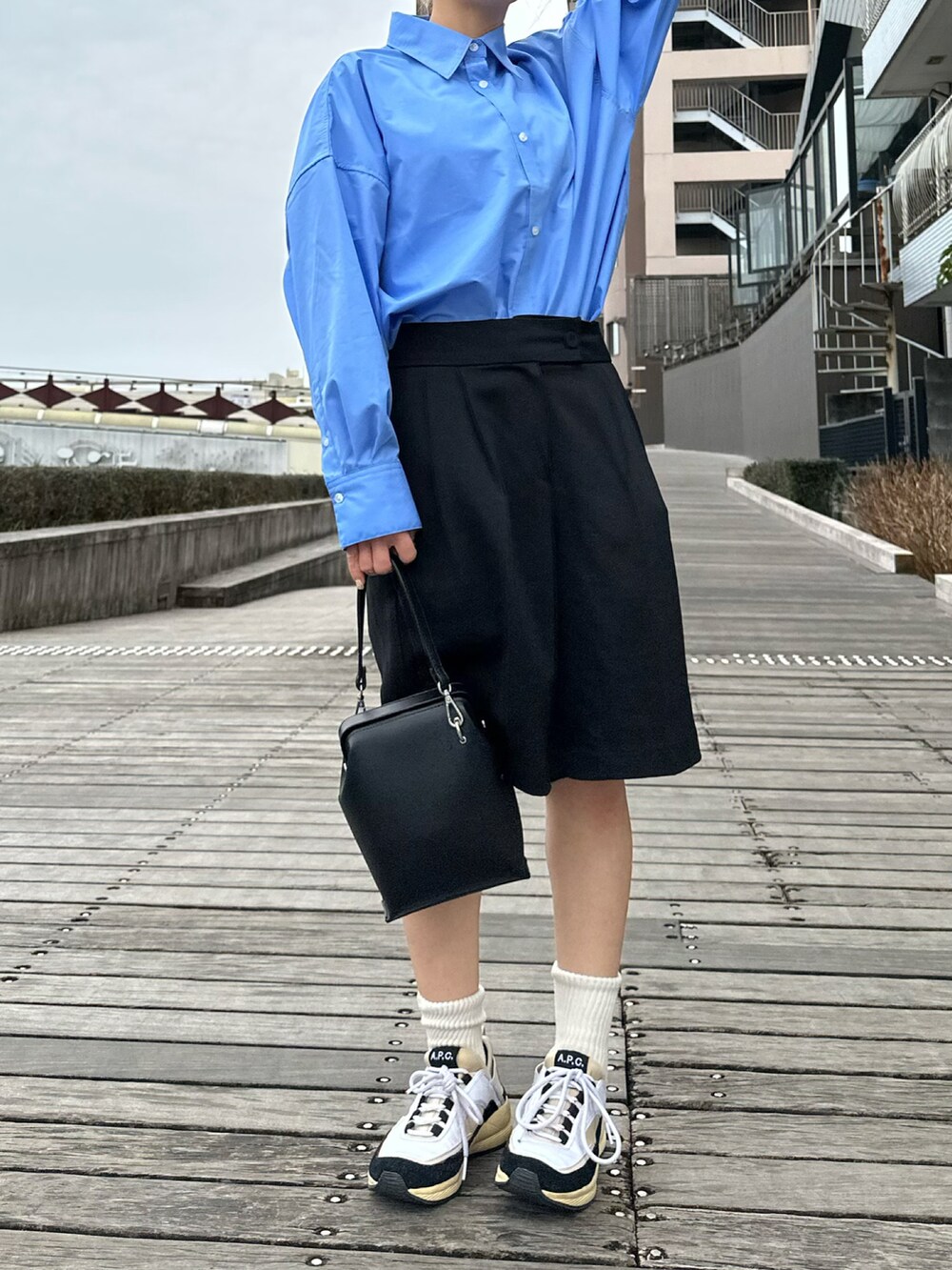 ブルー系のシャツ/ブラウス、ブラック系のバッグ、ホワイト系のスニーカーを着用したレディースの冬コーディネートの4枚目の写真