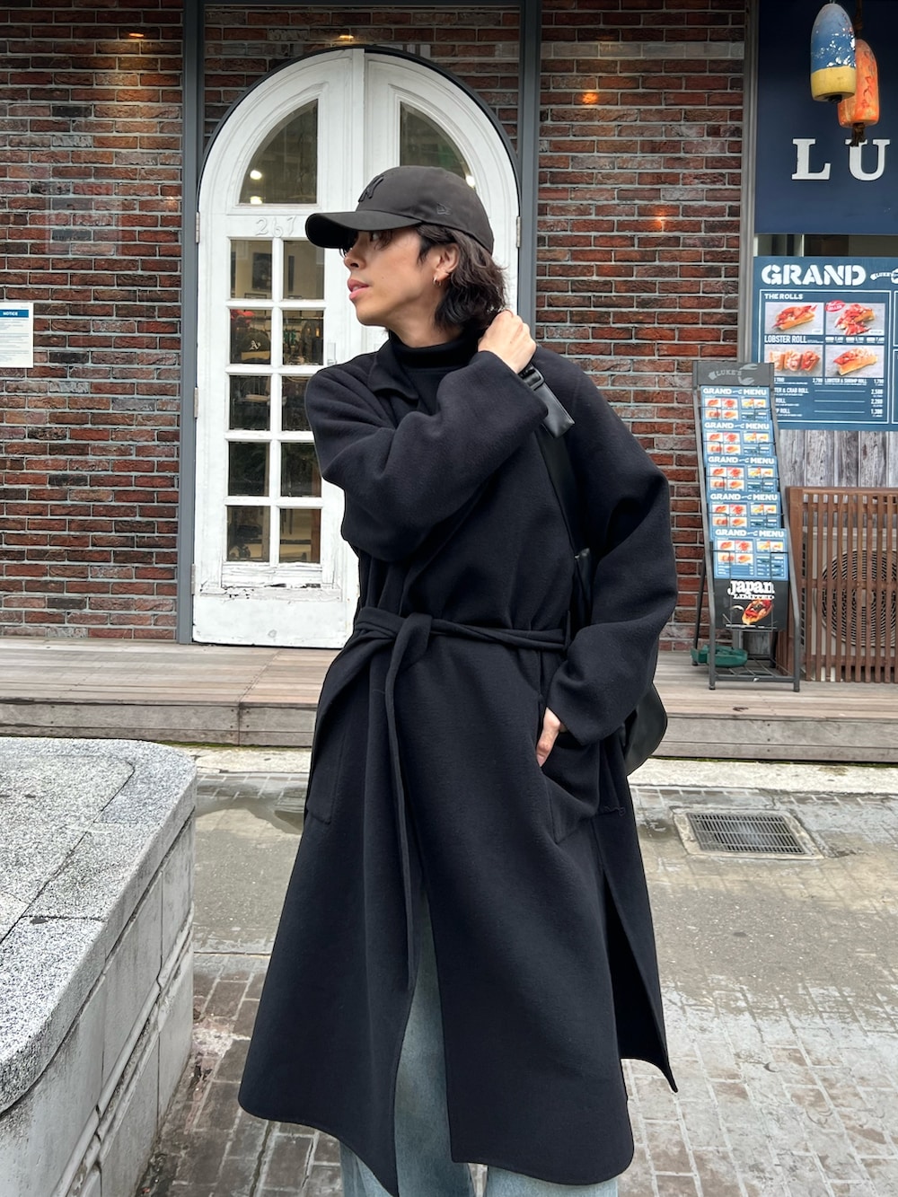 ブラック系のニット/セーター、ブラック系のショルダーバッグ、ブラック系のその他アウターを着用したメンズの秋コーディネートの3枚目の写真