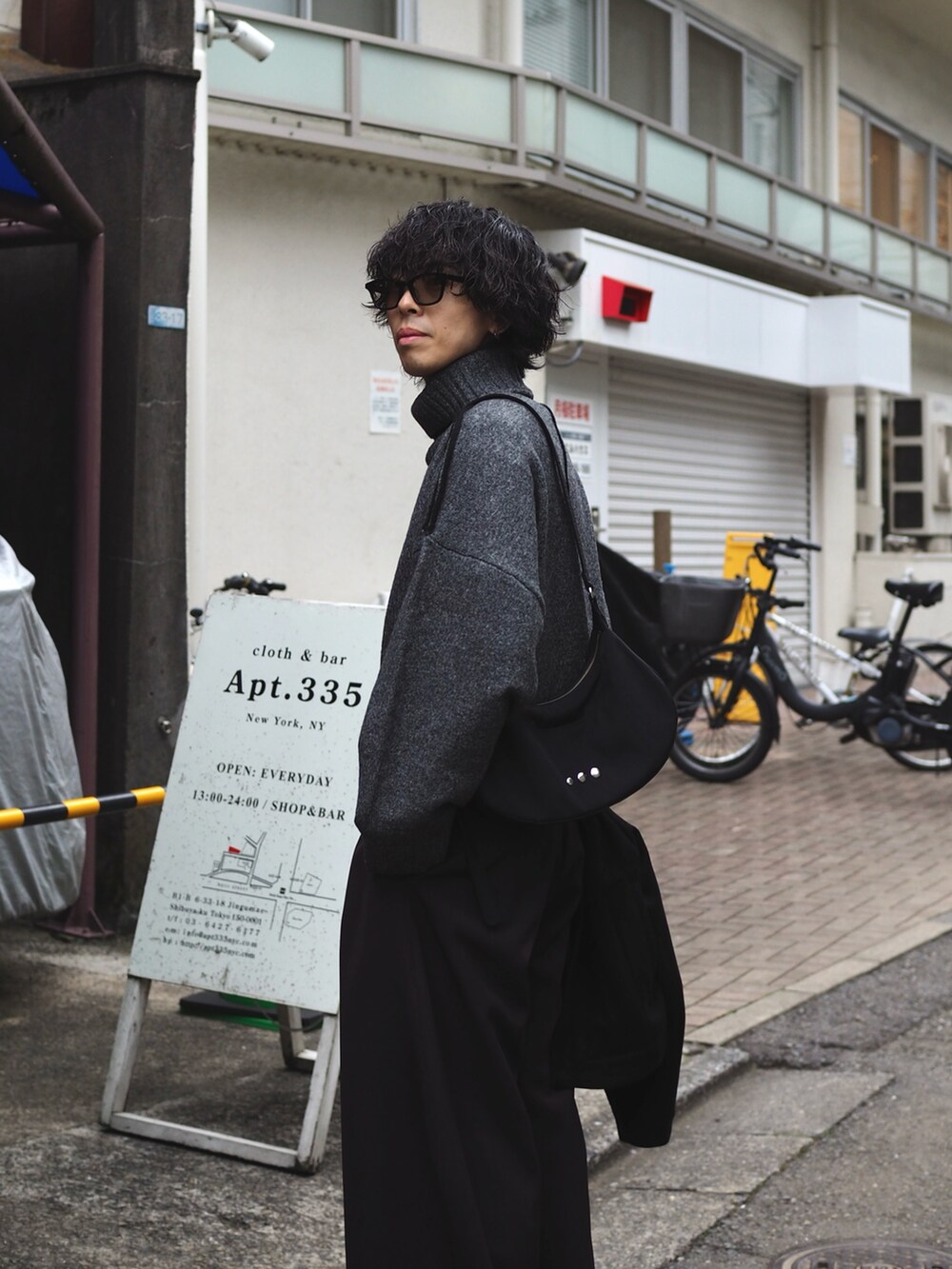 ブラック系のショルダーバッグ、グレー系のニット/セーター、グレー系のスラックスを着用したメンズの冬コーディネートの4枚目の写真