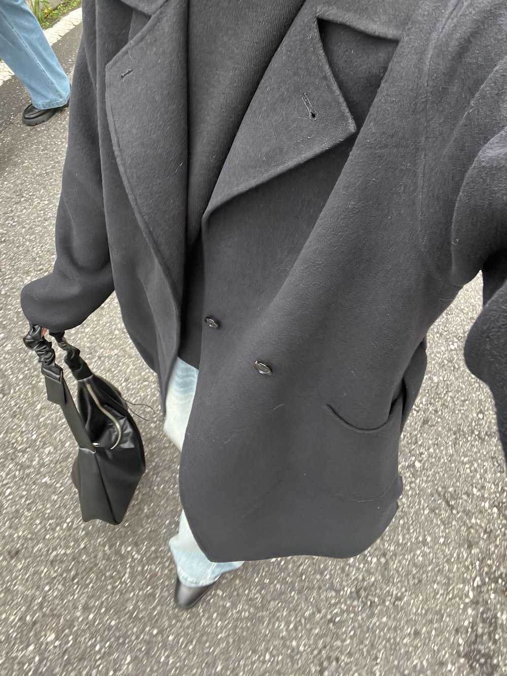 ブラック系のニット/セーター、ブラック系のショルダーバッグ、ブラック系のその他アウターを着用したメンズの秋コーディネートの5枚目の写真