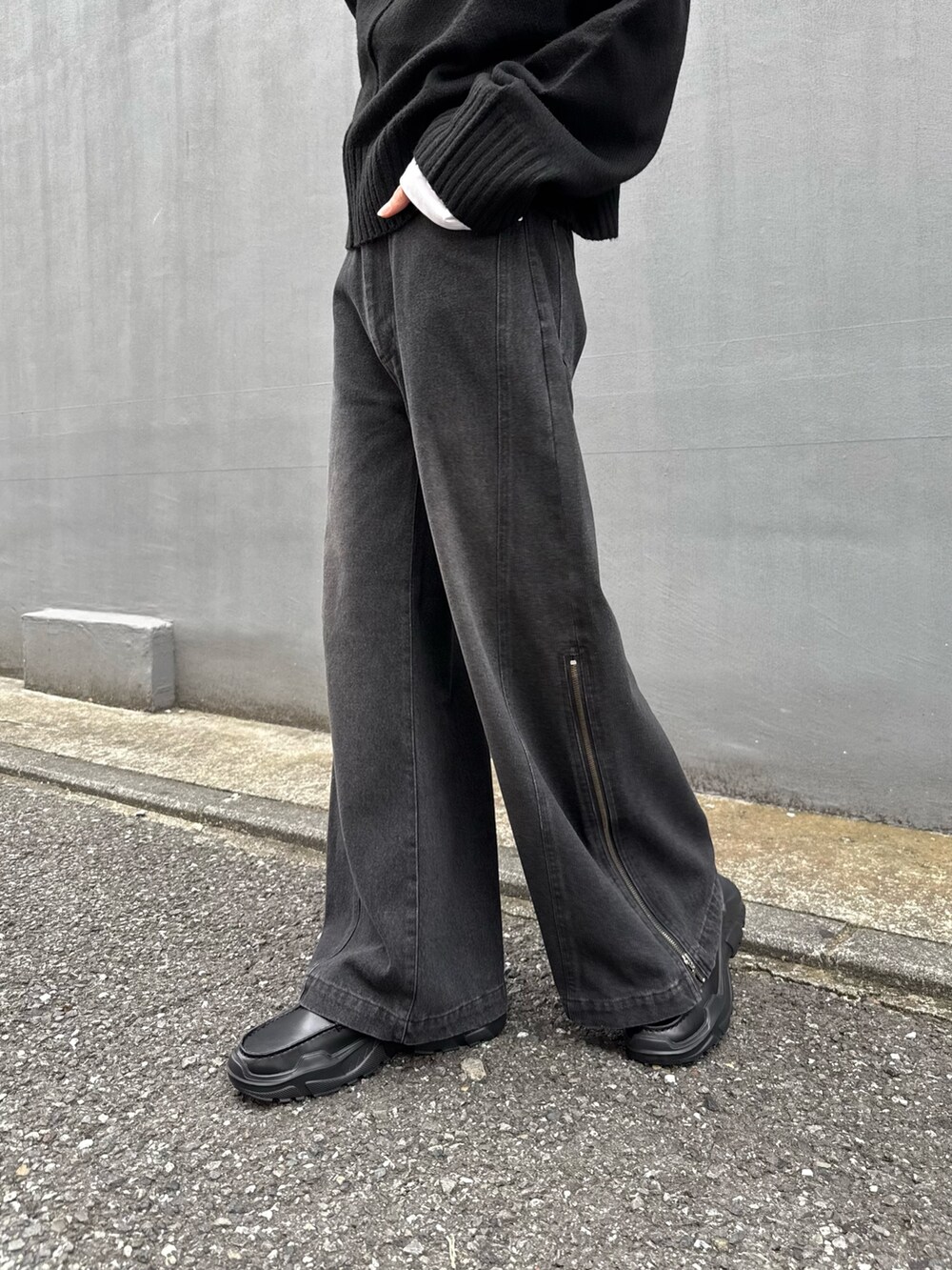 ブラック系のショルダーバッグ、ブラック系のニット/セーター、ブラック系のデニムパンツを着用したメンズの秋コーディネートの5枚目の写真