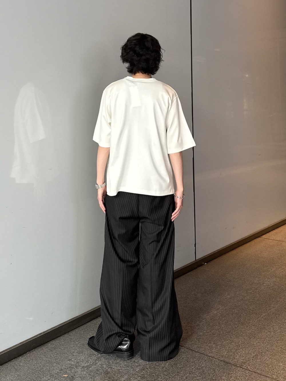 ホワイト系のTシャツ/カットソー、ブラック系のスラックス、シルバー系のネックレスを着用したメンズの夏コーディネートの4枚目の写真