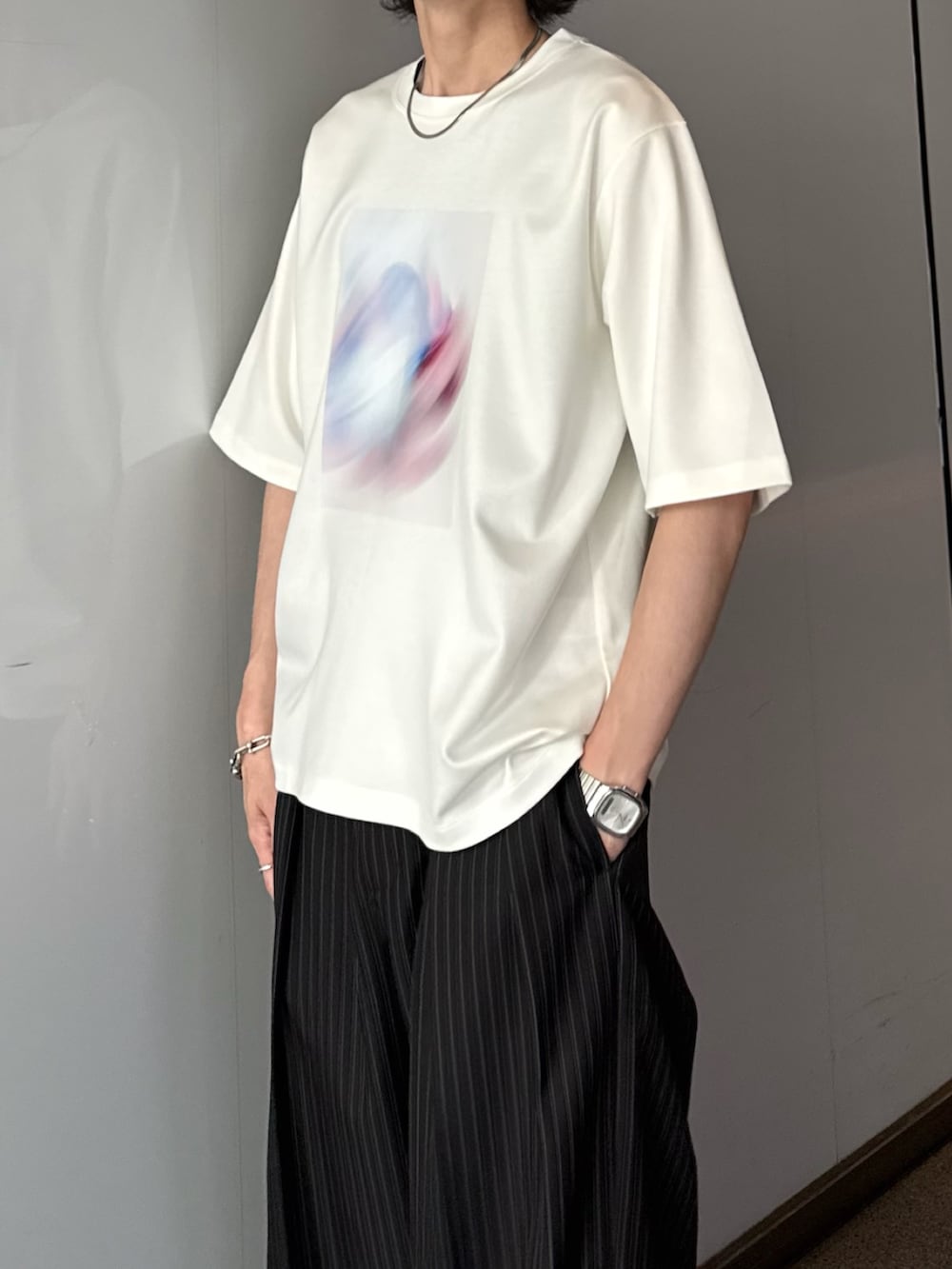 ホワイト系のTシャツ/カットソー、ブラック系のスラックス、シルバー系のネックレスを着用したメンズの夏コーディネートの6枚目の写真
