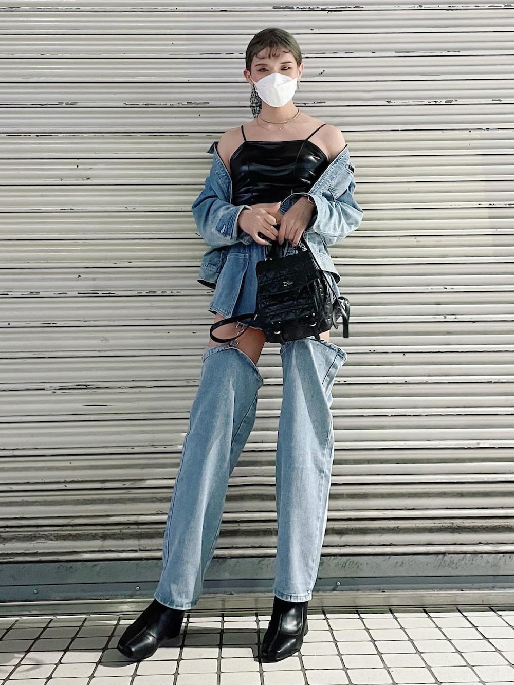 ブルー系のデニムジャケット、ブルー系のデニムパンツ、ブラック系のブーツを着用したレディースの春コーディネートの2枚目の写真