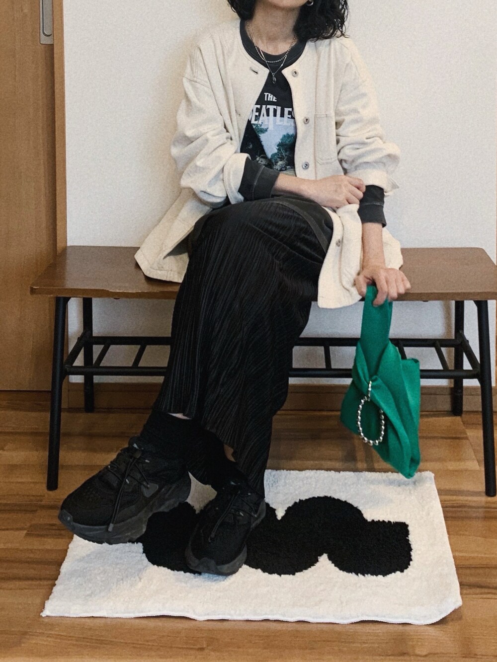 ブラック系のTシャツ/カットソー、グリーン系のトートバッグ、ブラック系のスニーカーを着用したレディースの春コーディネートの2枚目の写真