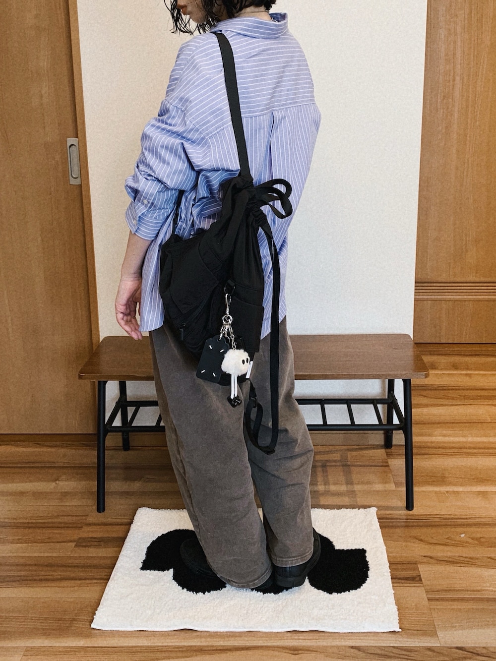 ブラック系のバックパック/リュック、ブラウン系のデニムパンツ、ホワイト系のTシャツ/カットソーを着用したレディースの春コーディネートの2枚目の写真