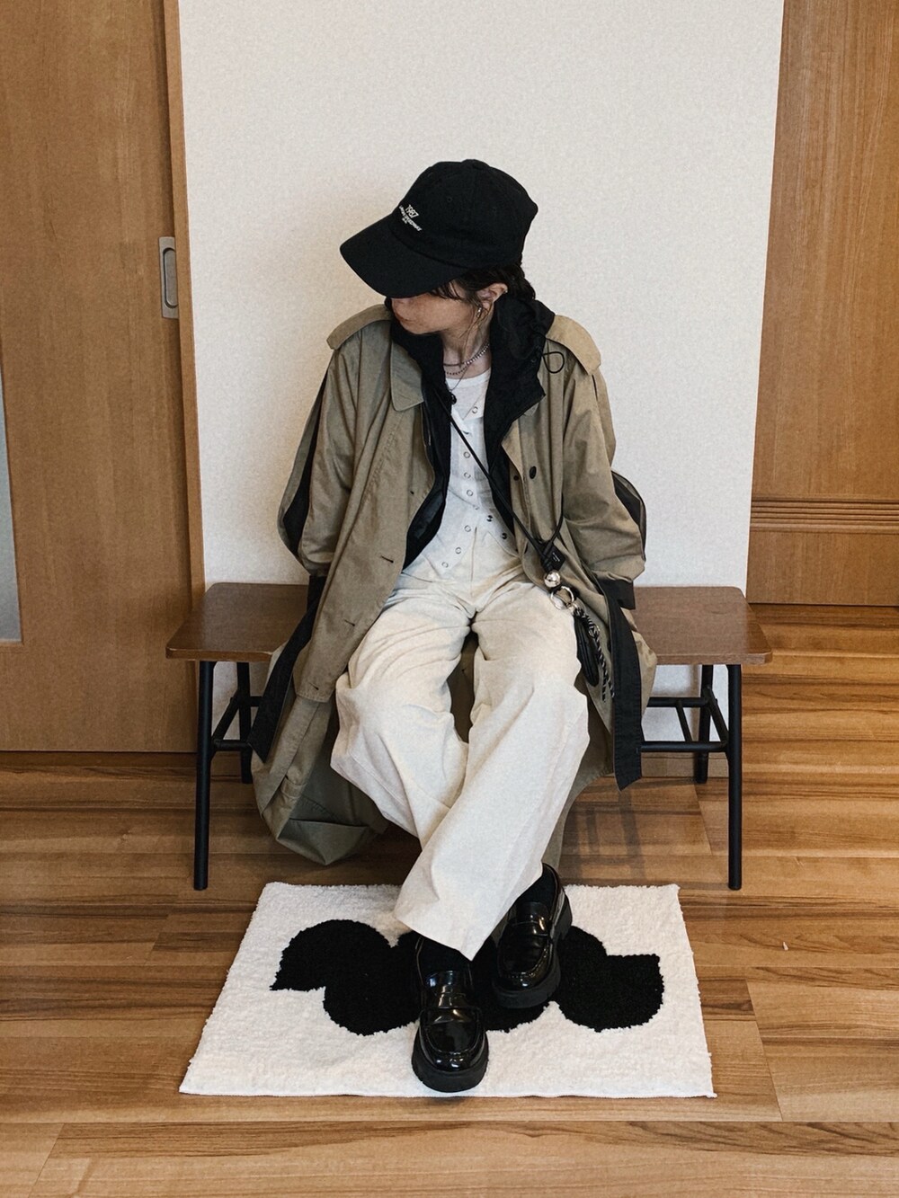 ブラック系のパーカー、ホワイト系のカーディガン/ボレロ、ホワイト系のその他パンツを着用したレディースの春コーディネートの2枚目の写真