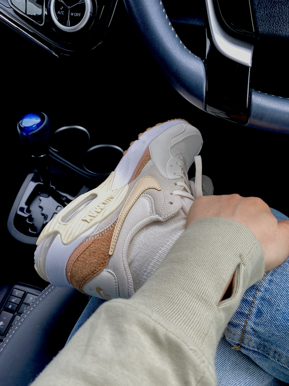 ブルー系のデニムパンツ、シルバー系のショルダーバッグ、ブラック系のチューブトップを着用したレディースの秋コーディネートの2枚目の写真