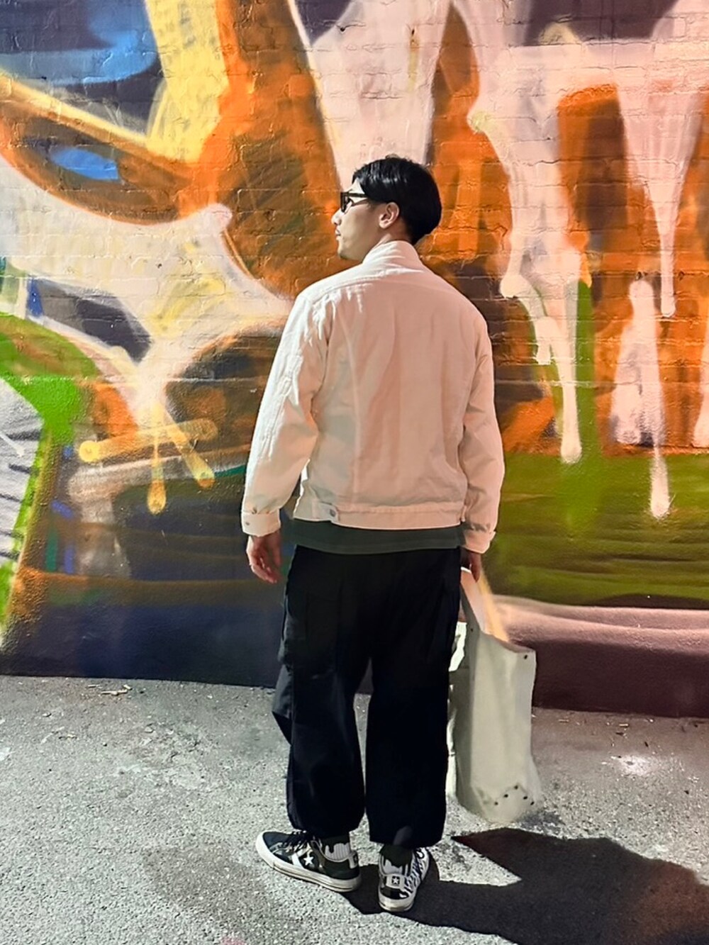 ホワイト系のジャケット/アウター、ブラック系のカーゴパンツ、ブラック系のスニーカーを着用したメンズの秋コーディネートの2枚目の写真