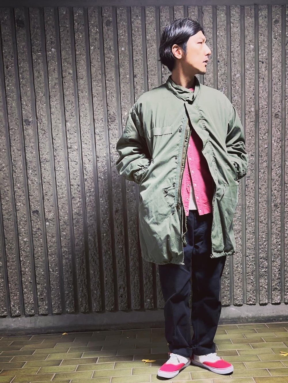 グリーン系のモッズコート、ブラック系のカーディガン/ボレロ、ブラック系のチノパンツを着用したメンズの冬コーディネートの3枚目の写真